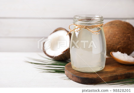 Coconut oil on white wooden table. Space for text 98828201