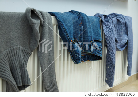 Different clothes drying on a radiator indoor Different clothes drying on a radiator indoor 98828309