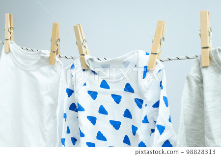 Child clothes hanging and drying on twine on light background Child clothes hanging and drying on twine on light background 98828313