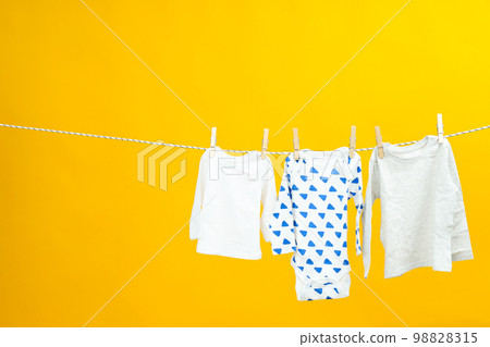 Laundry hanging and drying on twine on yellow background 98828315