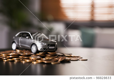 Miniature automobile model and money on table indoors, space for text. Car buying Miniature automobile model and money on table indoors, space for text. Car buying 98828633