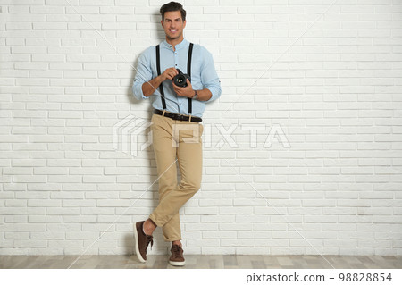Professional photographer working near white brick wall in studio. Space for text Professional photographer working near white brick wall in studio. Space for text 98828854