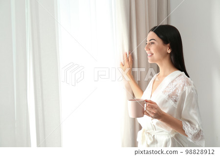 Abused young woman showing palm with word HELP near beige wall, focus on hand. Domestic violence  98828912