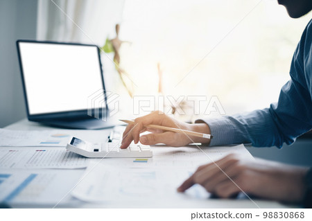 At Accounting office. Businessman calculating bills, tax and audit budget of company. statistics and credit analytic for mortgage payment concept. 98830868
