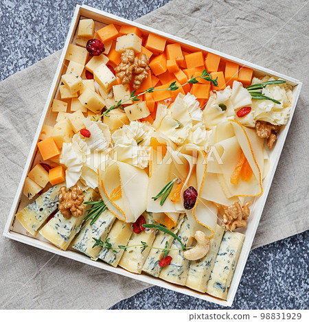 Assorted sorts of cheese on a wooden plate, grey background, top view 98831929