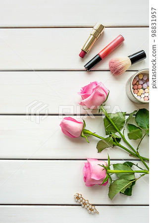 Top view arrangement with make-up, roses, hairpin and copy-space on white wooden background 98831957