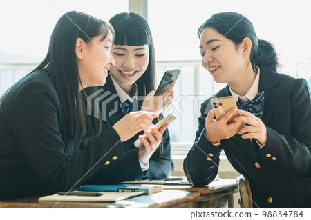 高中女生在學校教室裡使用智能手機 高中女生在學校教室裡使用智能手機 98834784