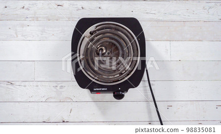 Flat lay. Portable one burner electric stove on the table. 98835081