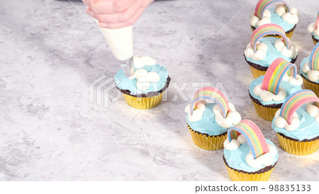 Step by step. Decorating chocolate cupcakes with buttercream frosting and rainbow candy. 98835133