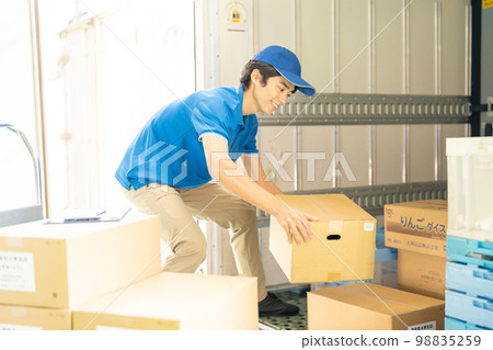 Male truck driver working in a warehouse Male truck driver working in a warehouse 98835259