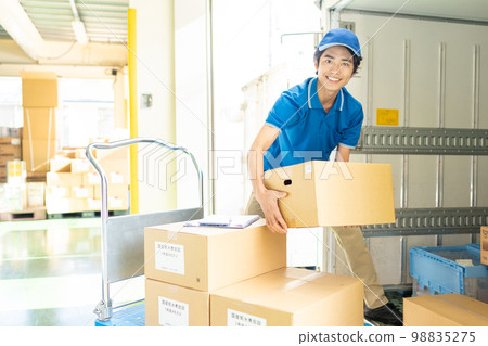 Male truck driver working in a warehouse 98835275