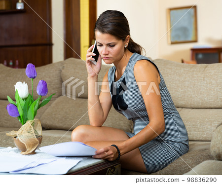 Girl filling out documents and talking on phone Girl filling out documents and talking on phone 98836290