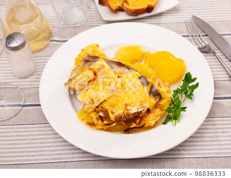 Grilled pork steak with gravy cheese and sliced potato on plate Grilled pork steak with gravy cheese and sliced potato on plate 98836333