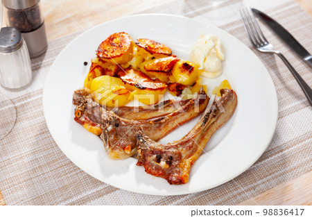 Grilled lamb rib chop steaks, medium rare with french fries on plate Grilled lamb rib chop steaks, medium rare with french fries on plate 98836417
