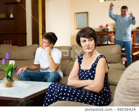 Disappointed woman with husband scolding teen son 98836424