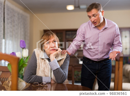 Elderly mother and adult son are offended at each other because of the misunderstanding in his home Elderly mother and adult son are offended at each other because of the misunderstanding in his home 98836561