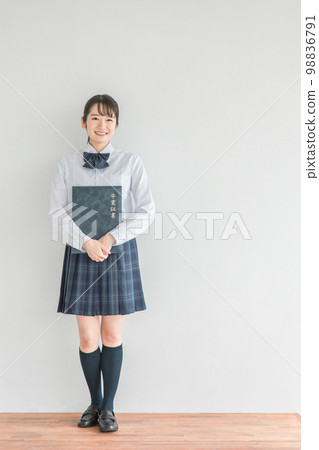 微笑的高中生、初中生、高中女生（畢業典禮、制服、校服）在學校教室裡拿著文憑和證書文件 98836791