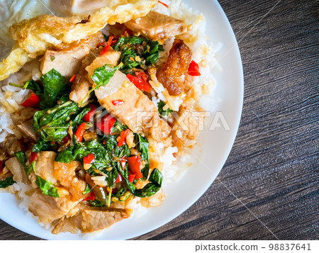 Rice topped with crispy pork belly with Thai basil and fried egg Rice topped with crispy pork belly with Thai basil and fried egg 98837641