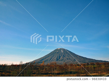 秋天的風景 蝦夷富士聳立在秋天的森林後面的深藍天空中 秋天的風景 蝦夷富士聳立在秋天的森林後面的深藍天空中 98838410