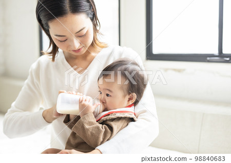 baby and mother drinking milk 98840683