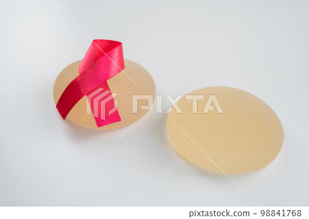 Breast implants and satin ribbon. Breast cancer awareness symbol. Breast implants and satin ribbon. Breast cancer awareness symbol. 98841768