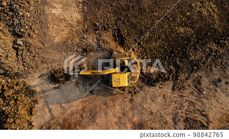 Aerial view of wheel loader excavator with backhoe unloading sand in construction site. 98842765