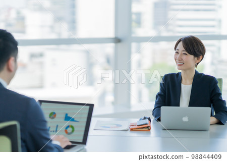 Young woman enthusiastically explaining at a meeting 98844409