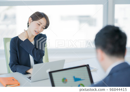 Career woman with stiff shoulders 98844415