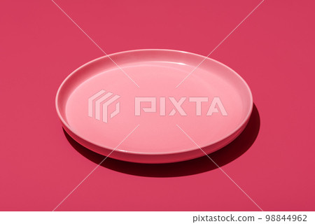 Pink plate isolated on a vibrant magenta background 98844962