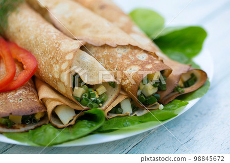 Delicious pancakes with green onions and egg on a wooden background Delicious pancakes with green onions and egg on a wooden background 98845672