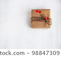 Gift box of craft paper with hearts on the white wooden background. Valentine's Day. 98847309