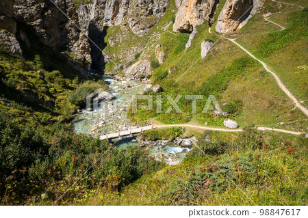 Mountain river and wood bridge in Vanoise national Park valley, French alps Mountain river and wood bridge in Vanoise national Park valley, French alps 98847617