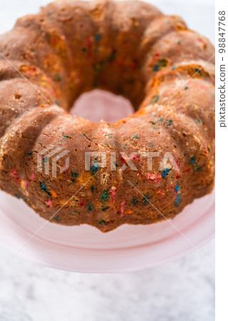 Close up view. Funfettti bundt cake prepared for frosting on a cake stand. 98847768