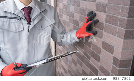 Worker inspecting the outer wall | Survey / estimate image Worker inspecting the outer wall | Survey / estimate image 98847861