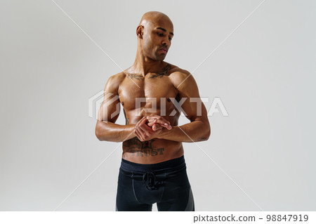 Portrait of sporty man with muscled naked body on white studio background and looking at side Portrait of sporty man with muscled naked body on white studio background and looking at side 98847919