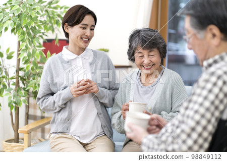 Caregiver and senior talking while drinking tea Caregiver and senior talking while drinking tea 98849112