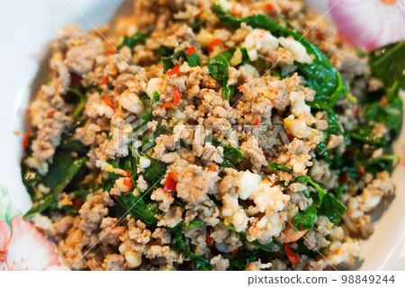 Minced pork and shrimp stir fried with green basil leaves and red hot chili with garlic, a famous Thai spicy dish called Phat Kraprao, usually homecook or order at streetfood or restaurant 98849244