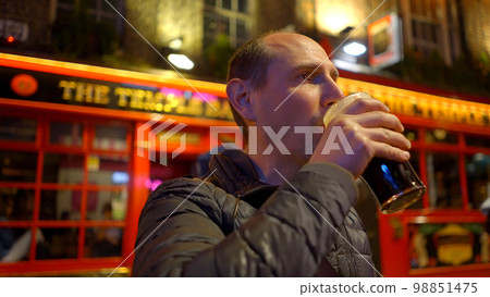 Guys drinking a beer in the Temple Bar district of Dublin by night - travel photography Guys drinking a beer in the Temple Bar district of Dublin by night - travel photography 98851475