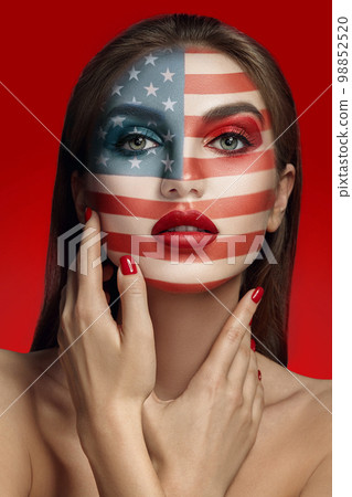 Close-up glamour portrait of a beautiful half-naked model with bright make-up posing over a red background. 98852520