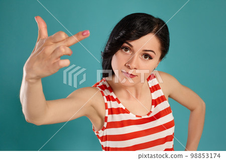 Close-up shot of a beautiful girl posing against a blue background. 98853174