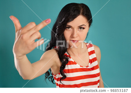 Close-up shot of a beautiful girl posing against a blue background. 98853187