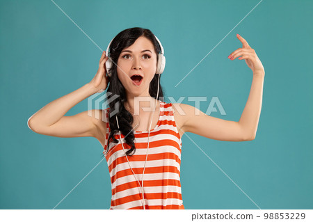 Studio photo of a gorgeous girl teenager posing over a blue background. 98853229