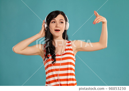 Studio photo of a gorgeous girl teenager posing over a blue background. 98853230