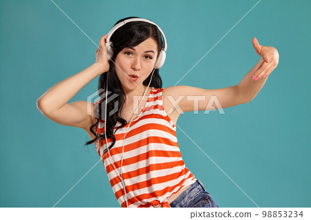 Studio photo of a gorgeous girl teenager posing over a blue background. 98853234