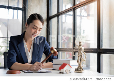 selective focus image, A professional millennial Asian female lawyer pr attorney holding a judge gavel or judge hammer at her desk selective focus image, A professional millennial Asian female lawyer pr attorney holding a judge gavel or judge hammer at her desk 98855666