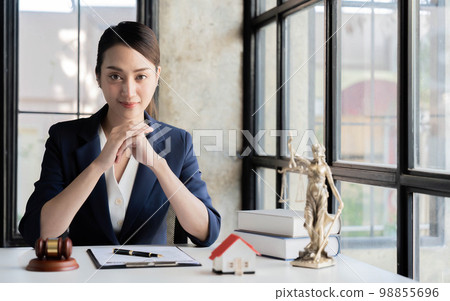 Portrait smiling female lawyer sitting at workplace in office 98855696