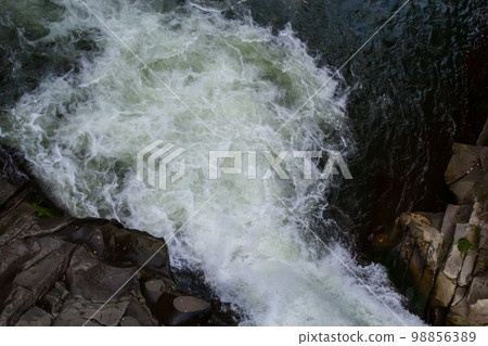 The stream of water flowing over rocks.Image close-up The stream of water flowing over rocks.Image close-up 98856389