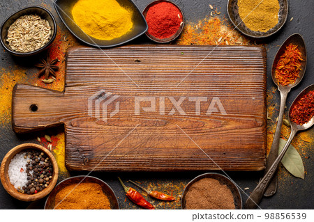Empty cutting board over various spices 98856539