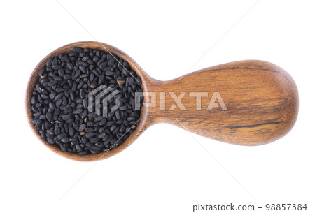 Black cumin seeds in wooden spoon, isolated on white background. Heap of black nigella seeds. Nigella sativa. Top view. 98857384