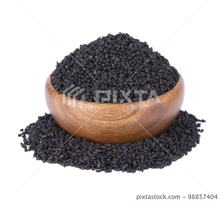 Black cumin seeds in wooden bowl, isolated on white background. Heap of black nigella seeds. Nigella sativa. Black cumin seeds in wooden bowl, isolated on white background. Heap of black nigella seeds. Nigella sativa. 98857404
